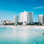 Scenic view of modern hotels along the beachfront in Cancun, Mexico, with clear blue waters.